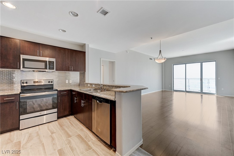 Kitchen with never before used stainless steel appliances, open floor plan, granite countertops, and stylish backsplash