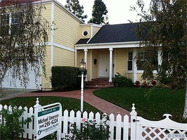 Your yellow Cape Cod style home with the brick wal