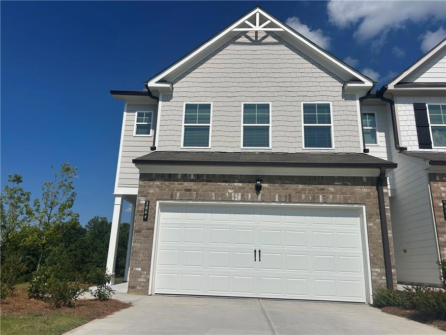 View of front of home featuring brick siding, driveway, and a garage