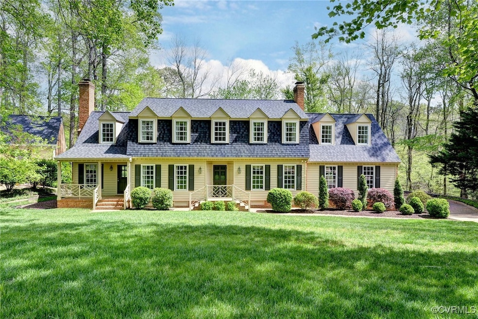 New england style home with a front yard, roof wit