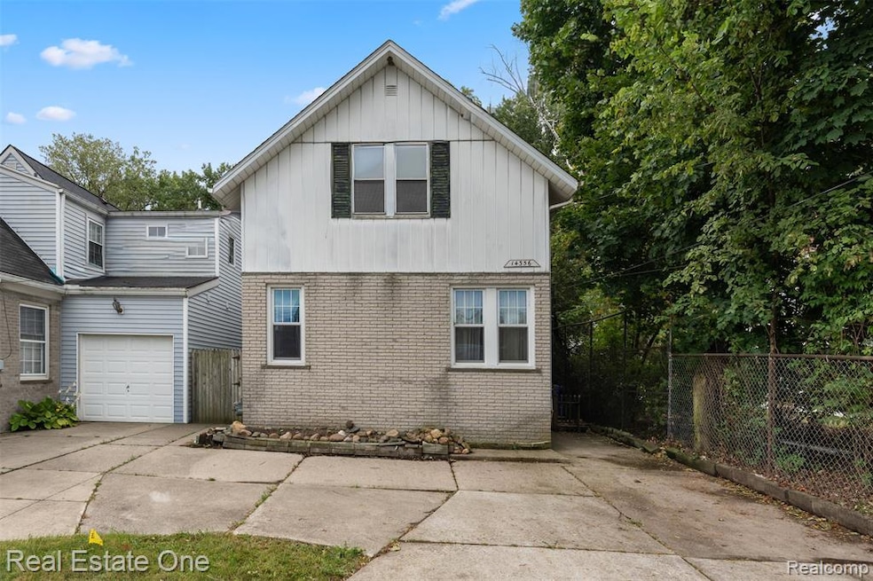 View of front of home featuring brick siding, driveway, board and batten siding, and a garage