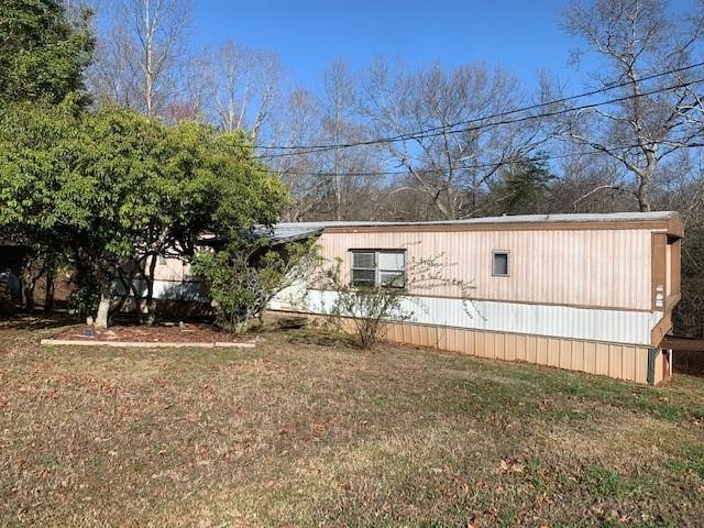 View of property exterior with a lawn