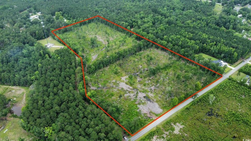 Aerial overview of property's location featuring property parcel outlined and a heavily wooded area