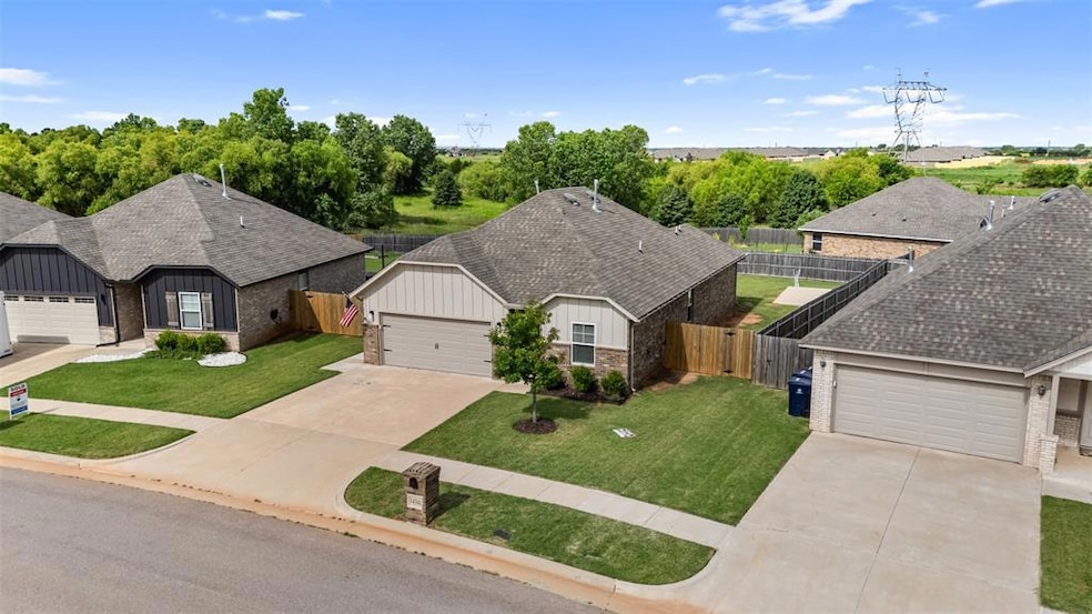View of front facade with driveway, brick siding, board and batten siding, and roof with shingles