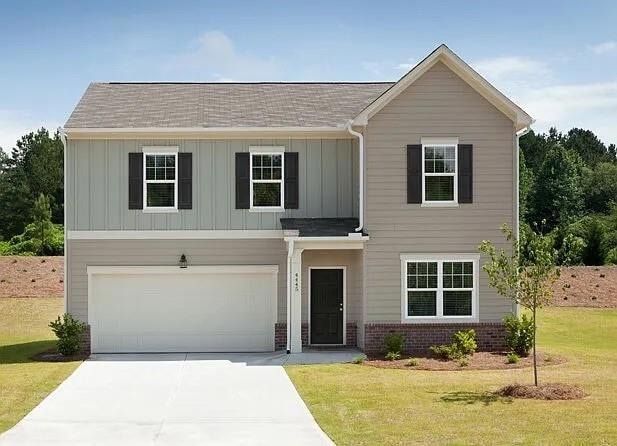 View of front of property with board and batten siding, an attached garage, brick siding, and a front yard