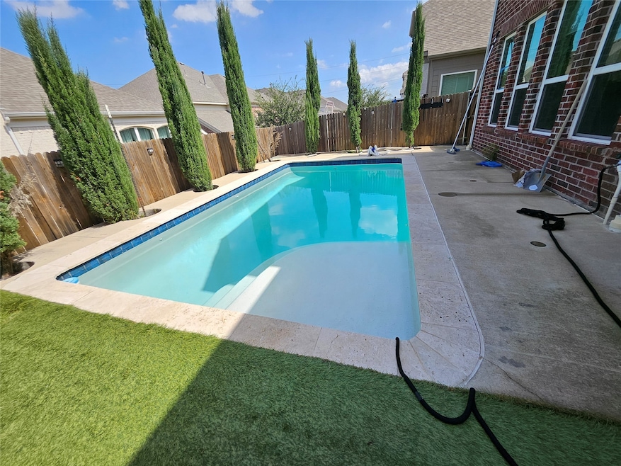 View of swimming pool with a fenced backyard and a patio