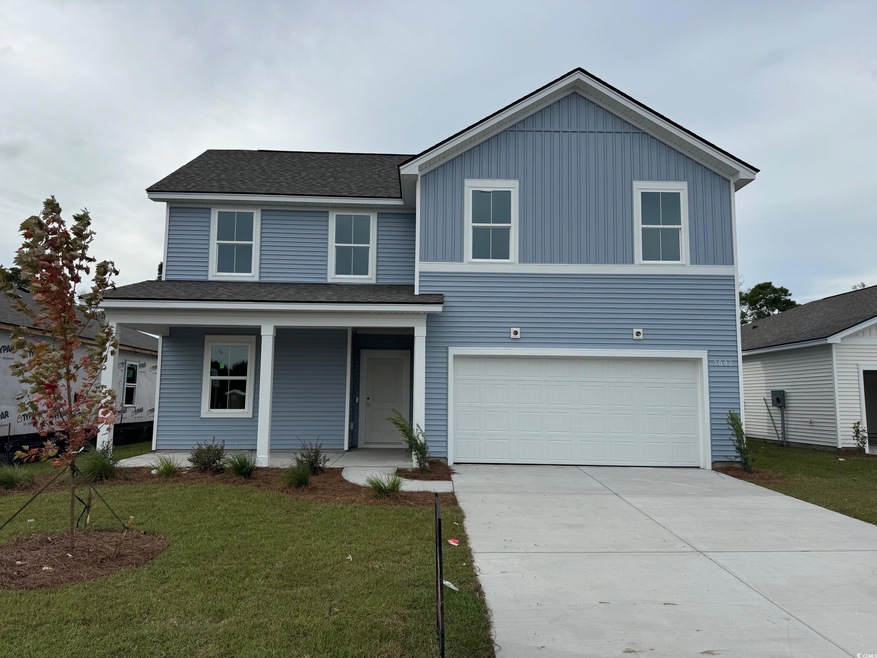View of front of home with covered porch, a front yard, a shingled roof, an attached garage, and concrete driveway