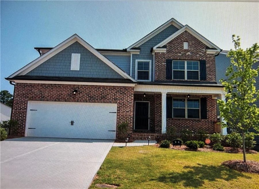 Craftsman house featuring a porch, driveway, a front yard, an attached garage, and brick siding