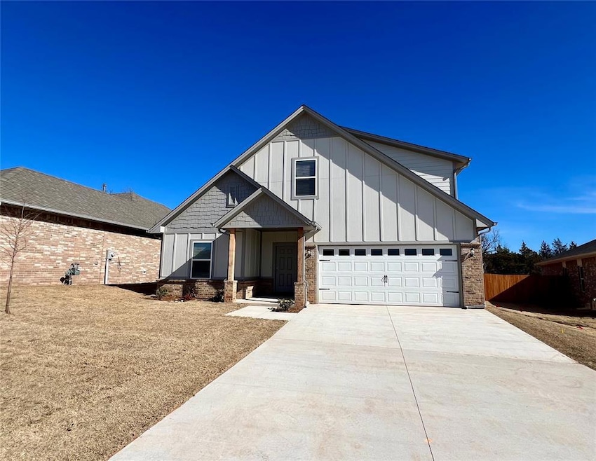 View of front facade with driveway, board and batten siding, and brick siding