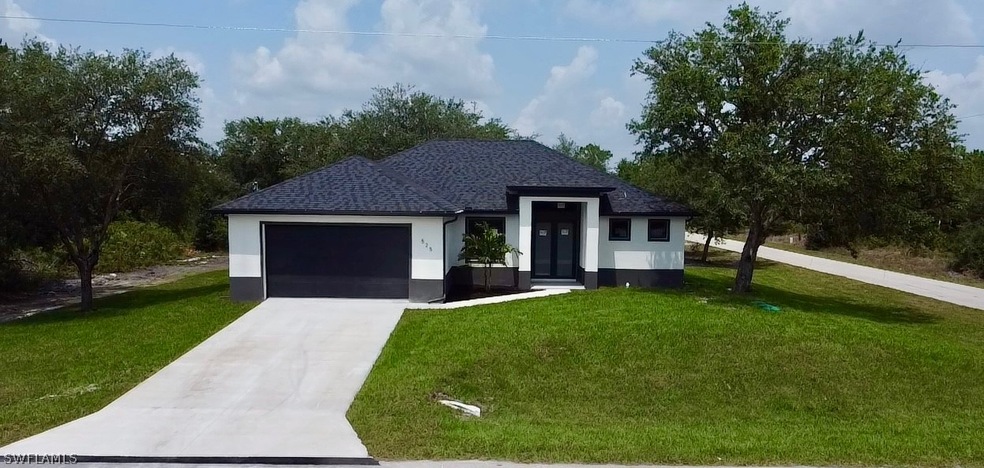 View of front of home with a garage and a front lawn