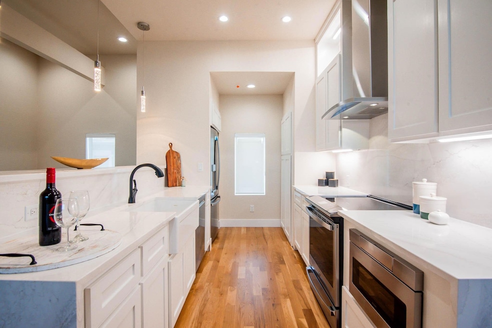 Kitchen featuring tasteful backsplash, wall chimne