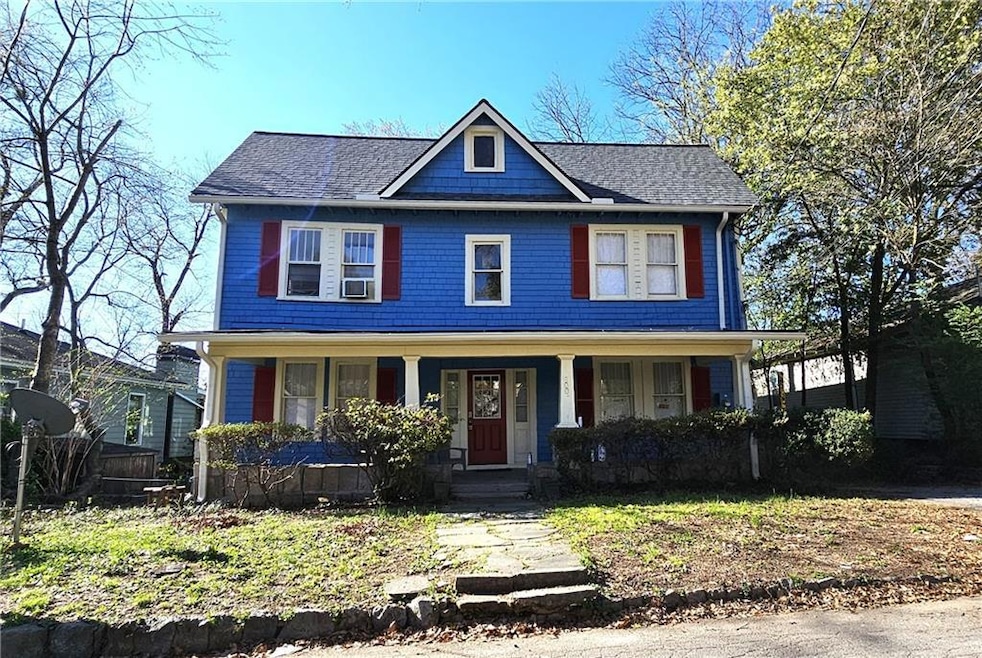 View of front of property featuring covered porch and roof with shingles