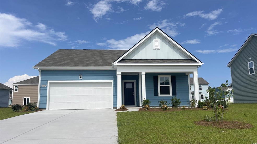 View of front facade with driveway, board and batten siding, an attached garage, a front lawn, and a porch