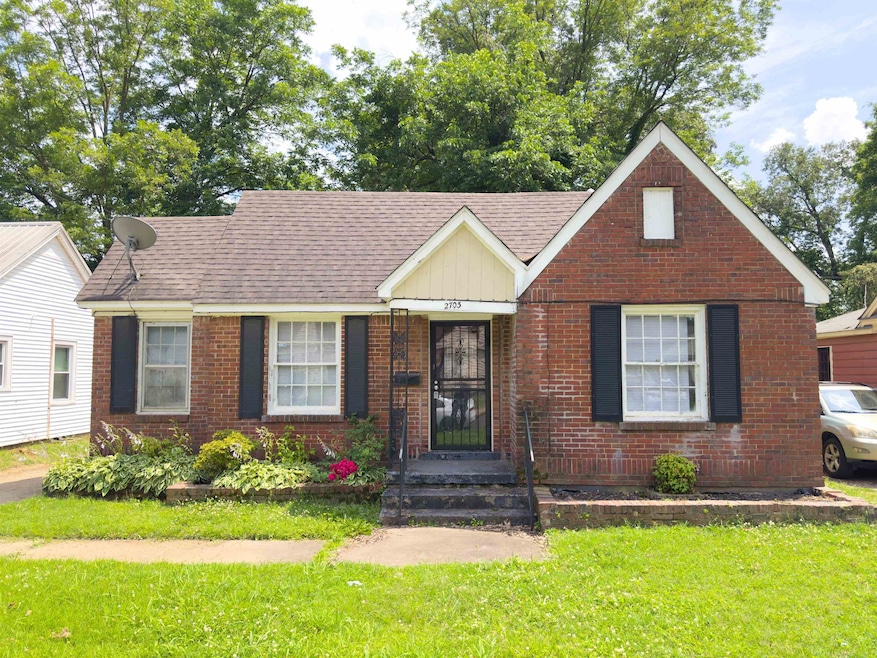 View of front of home with a front lawn, roof with shingles, and brick siding