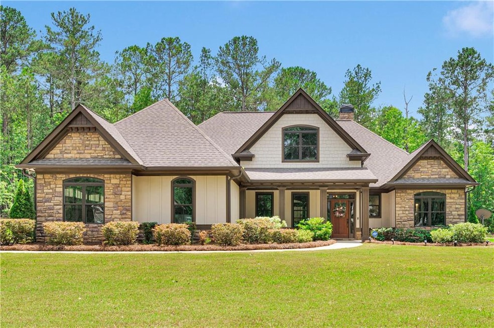 Craftsman inspired home with a chimney, stone siding, and a front yard