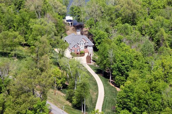 Aerial photo shows Lake Barkely behind house, winding driveway and wooded lot.