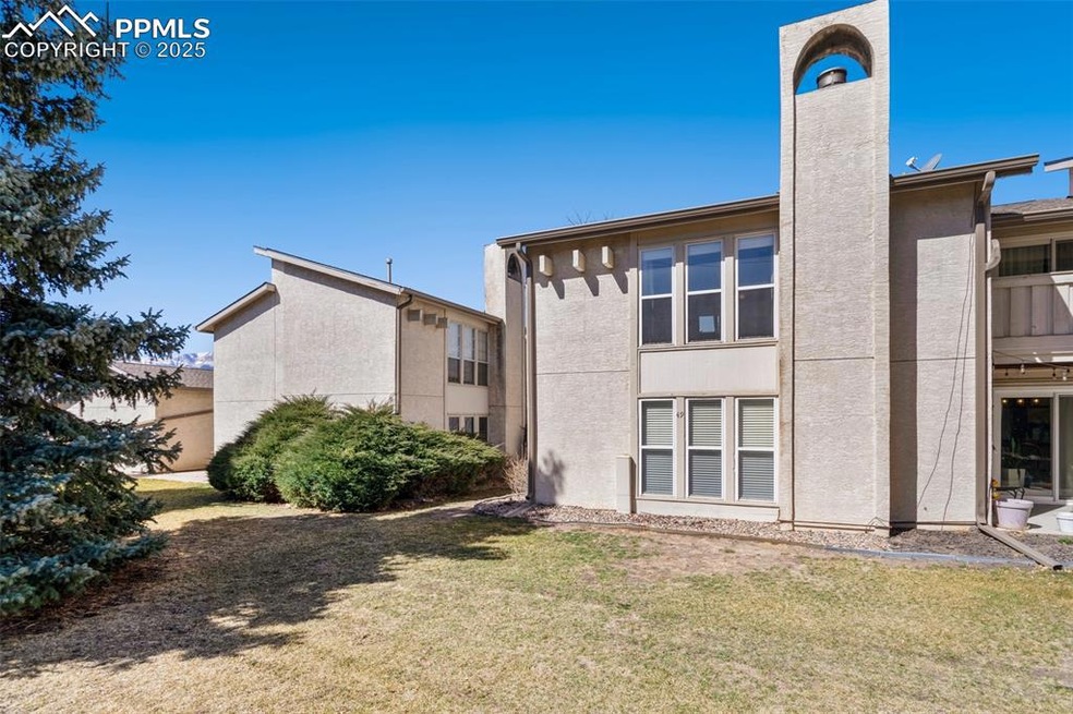 Back of property with stucco siding, a lawn, and a