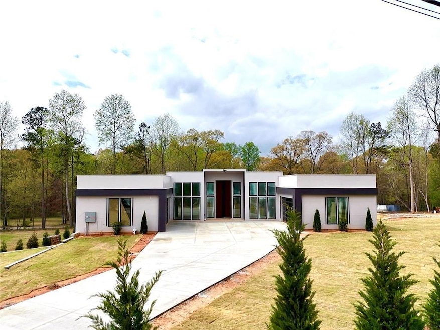 View of front of house featuring a front lawn, stucco siding, and concrete driveway