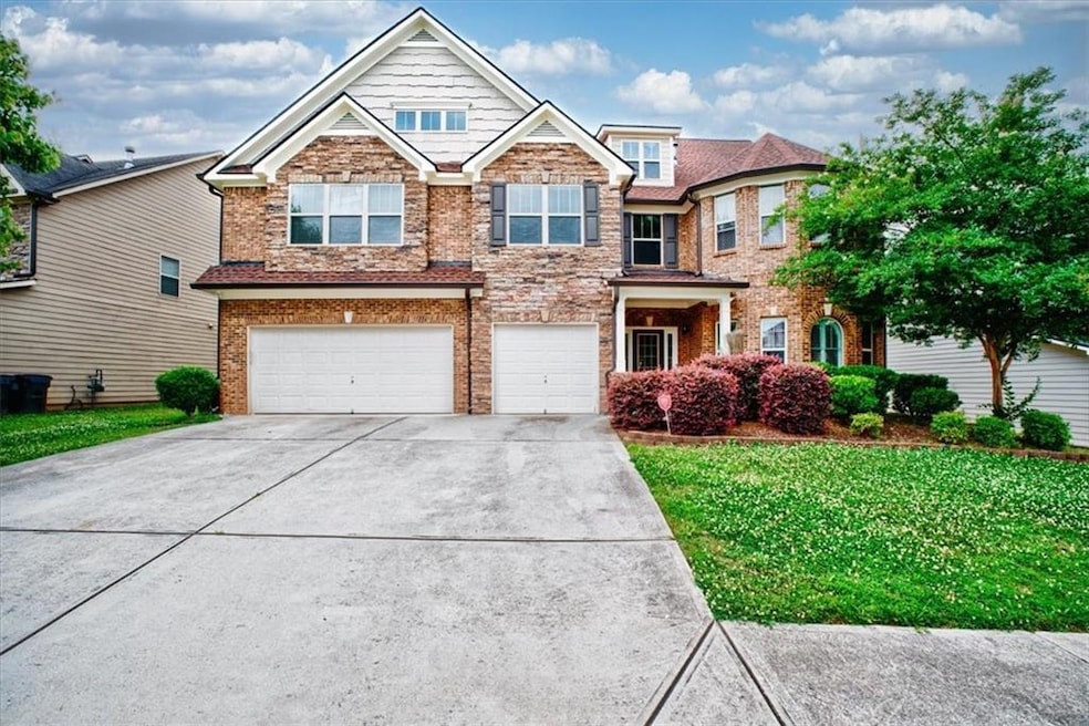View of front of property with concrete driveway, a garage, a front yard, and brick siding