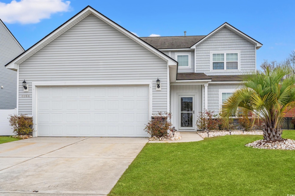 Traditional-style house featuring a garage, drivew