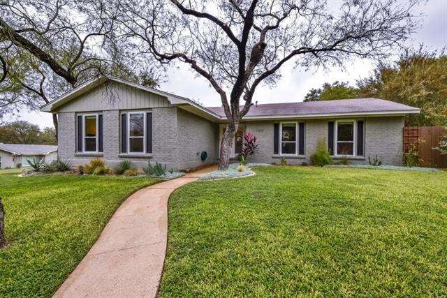 The lovely brick and hardiplank home sits on a lar
