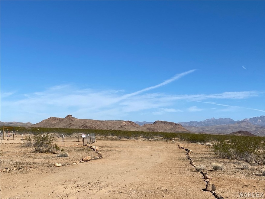 Entering driveway off Tuzigoot,  cleared and landscape with Mountains and blue skies in the background.