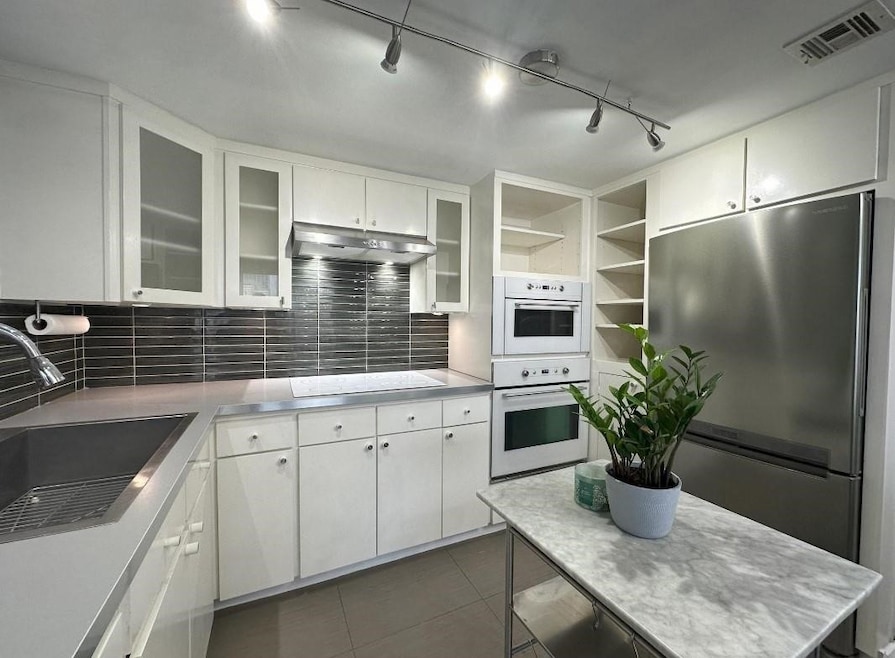 This stylish kitchen boasts clean lines, modern ap