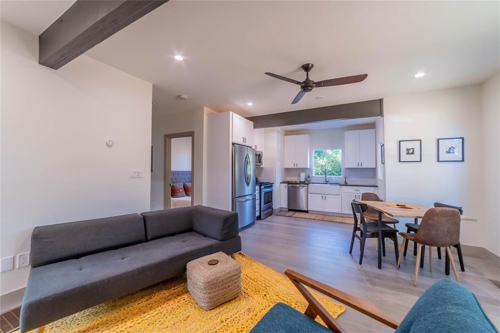 Living room with a ceiling fan, light wood-type f