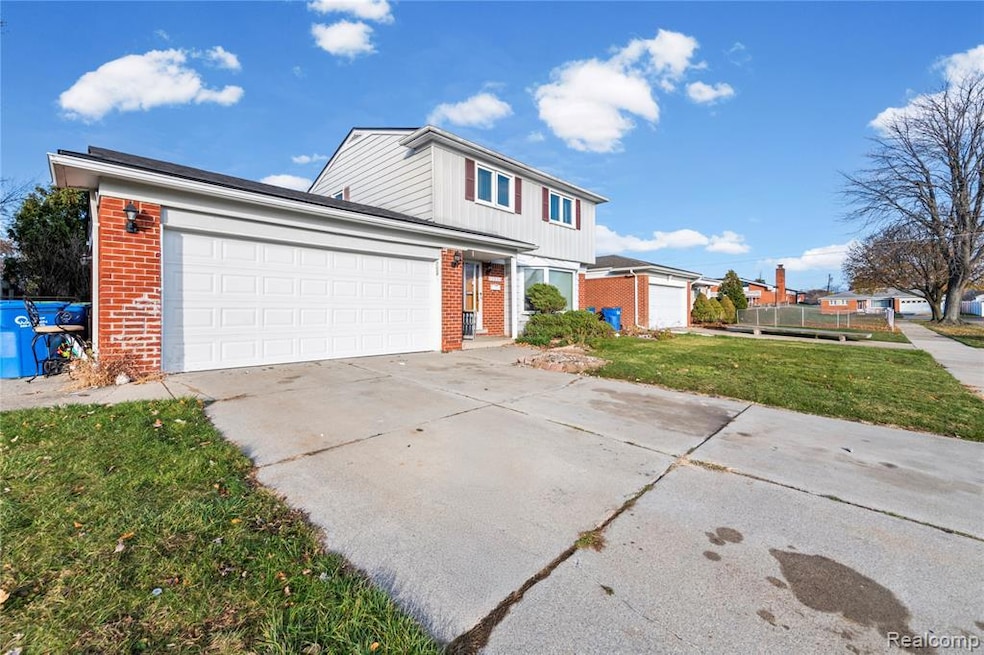 Traditional-style home featuring brick siding, driveway, and an attached garage