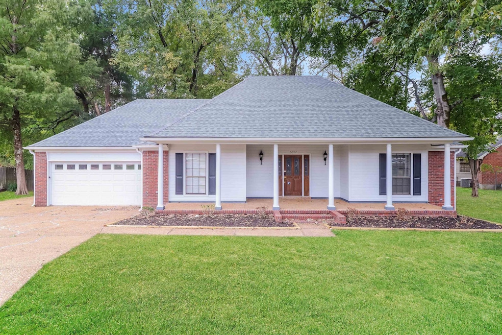 View of front of property featuring covered porch, a shingled roof, a front lawn, and driveway