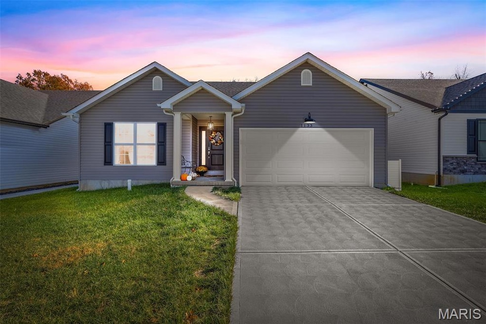 Ranch-style house featuring driveway, a lawn, and an attached garage
