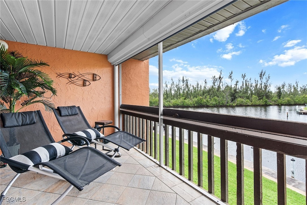 Balcony with a water view and view of wooded area