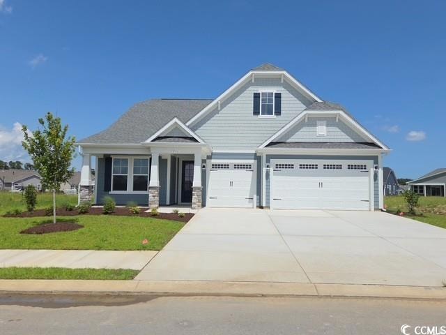 Craftsman-style home with driveway, a front lawn, and an attached garage