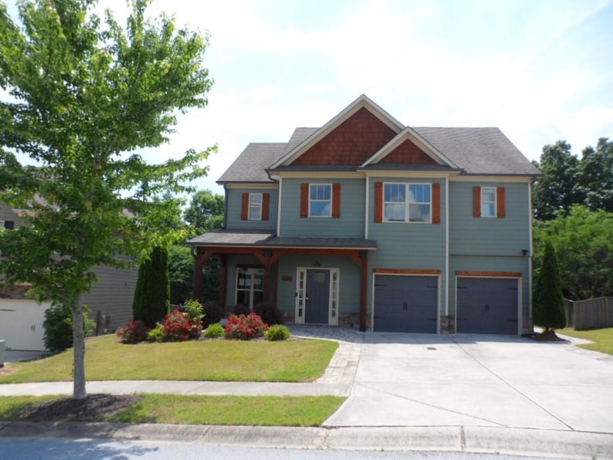 Craftsman-style house with concrete driveway, a garage, a front lawn, and a porch