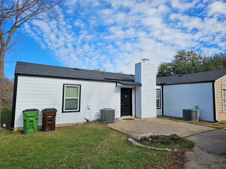 Back of house featuring a patio, a lawn, a chimney, and roof with shingles