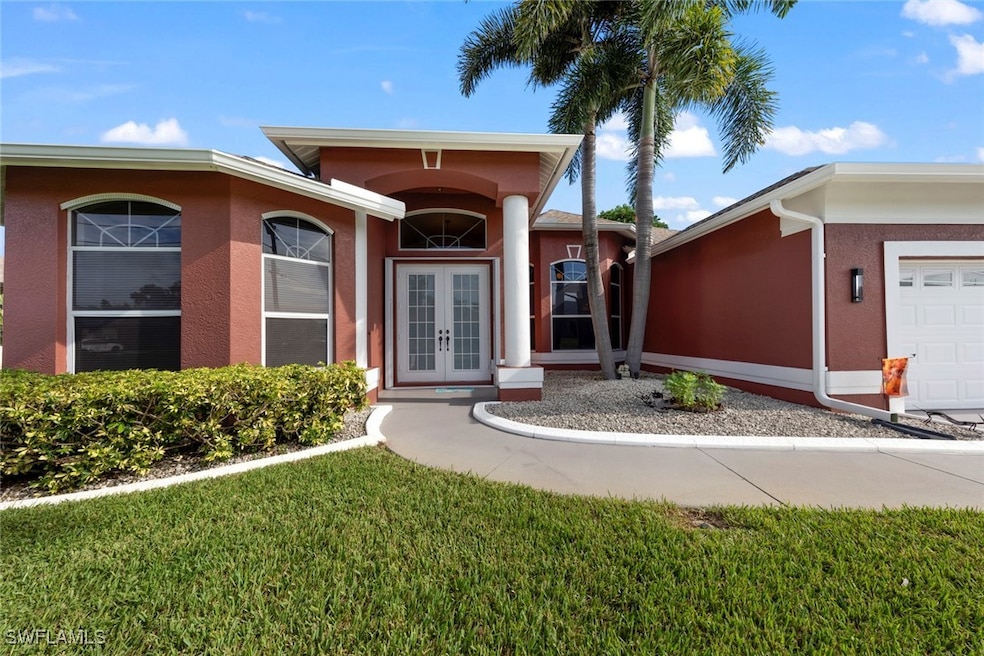 View of exterior entry featuring a garage and a lawn