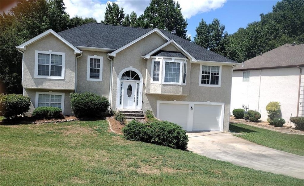 View of front facade featuring a garage and a front yard