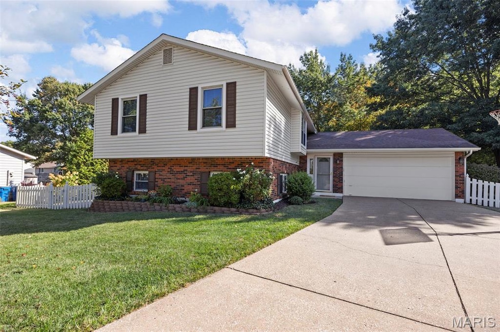 Split level home with brick siding, driveway, and an attached garage