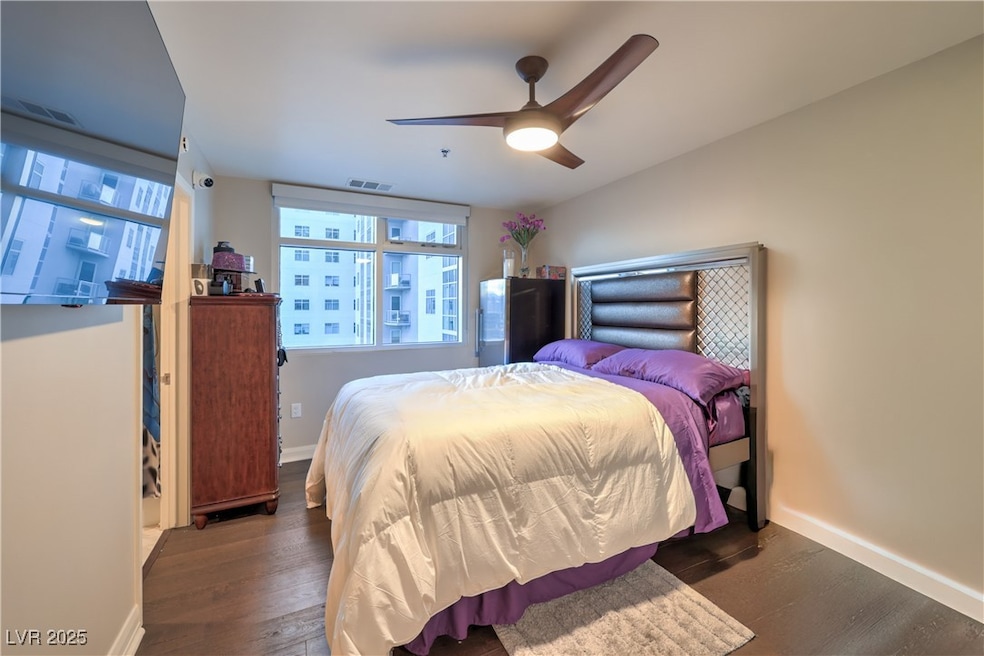 Bedroom with wood finished floors, baseboards, and