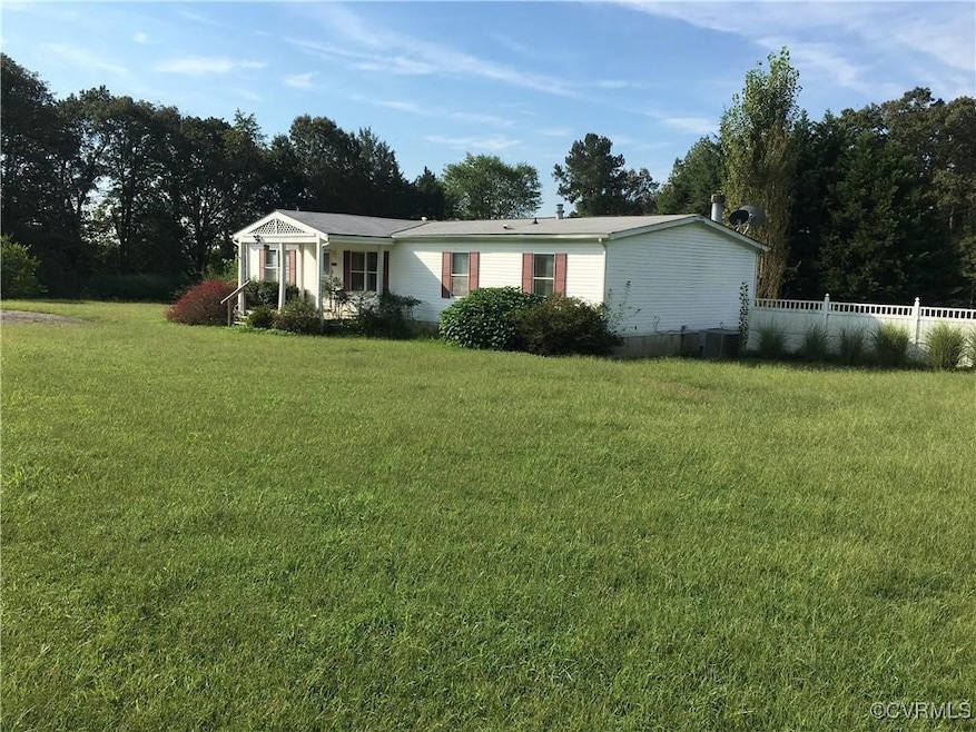 View of front facade with a front lawn and fence