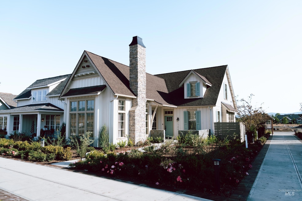 View of front of house with board and batten siding, roof with shingles, and a chimney