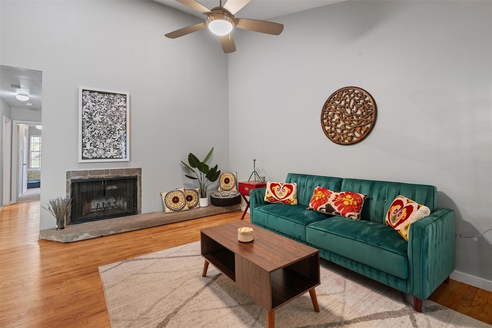 Living room featuring a ceiling fan, wood finishe