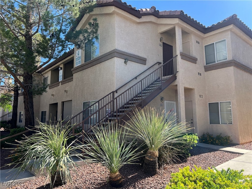 View of side of home with stucco siding, stairs, a