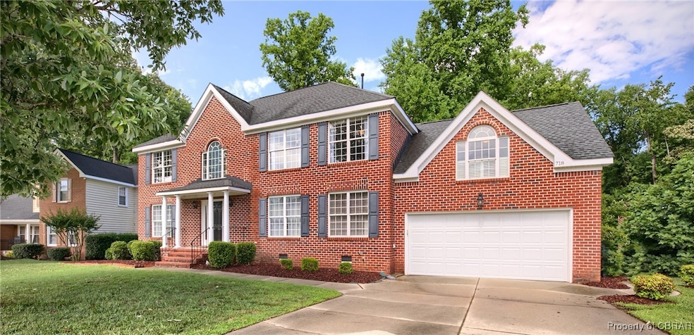 Colonial inspired home with a front lawn and a gar