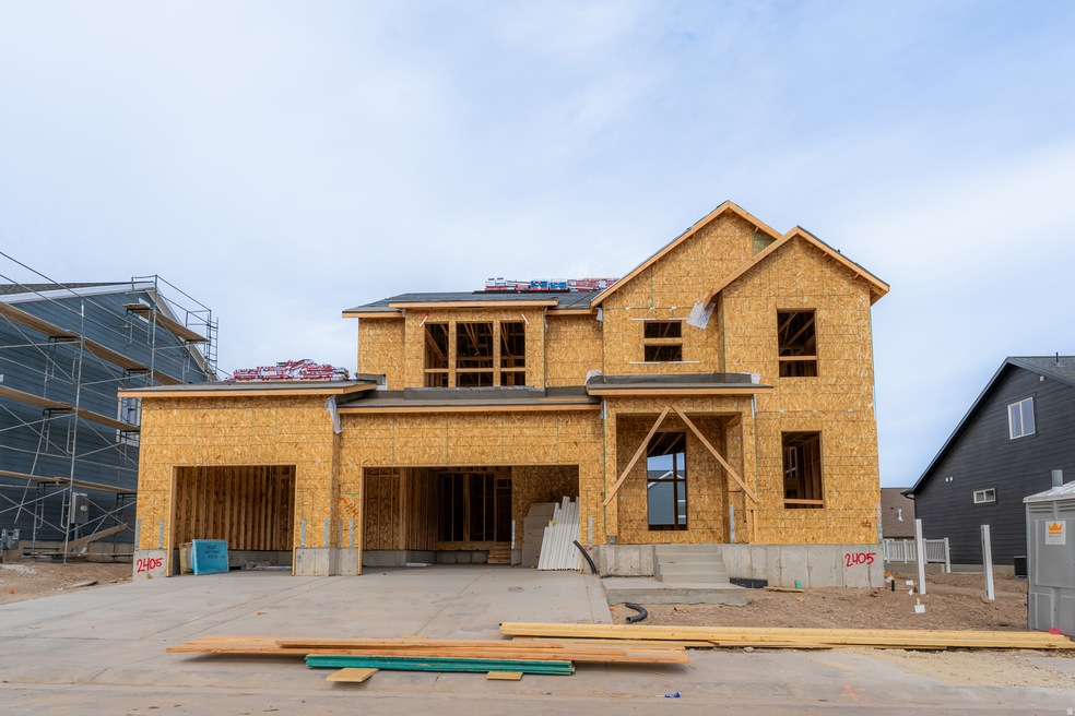 Property under construction with a garage, driveway, and brick siding