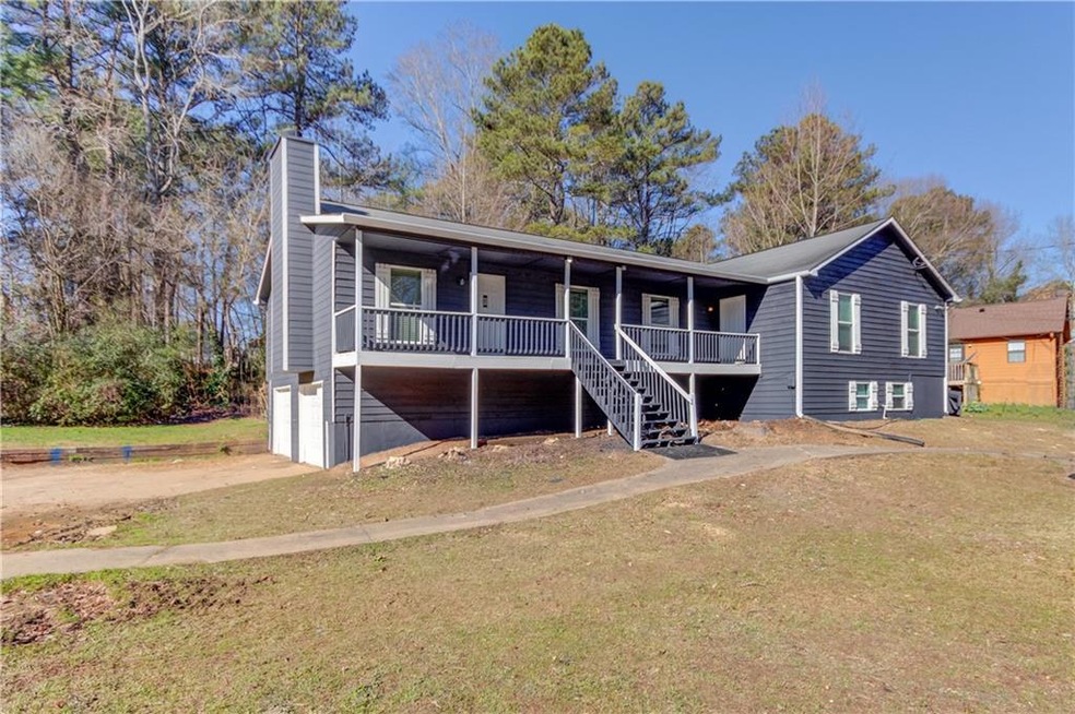 Back of property featuring a garage, a porch, and 