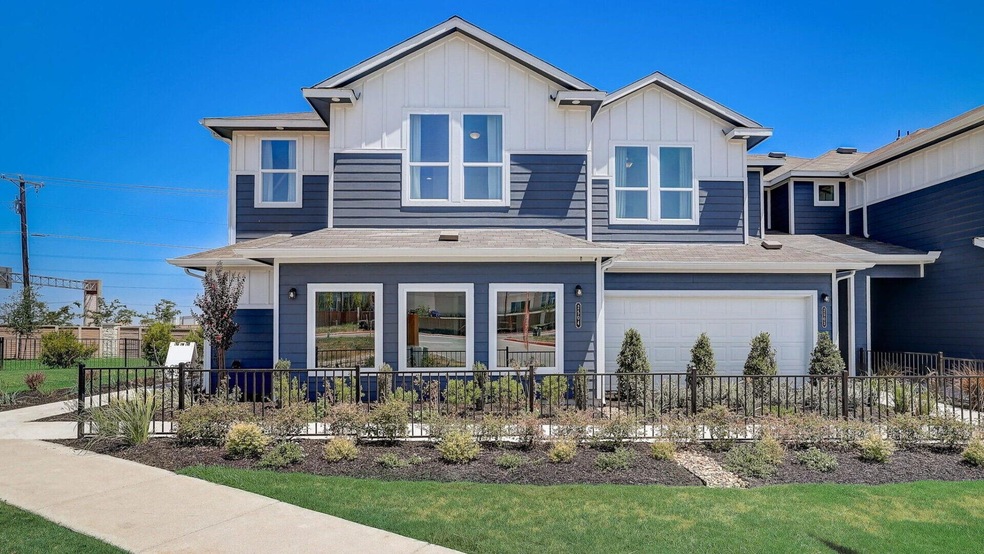 View of front of property with fence, board and b