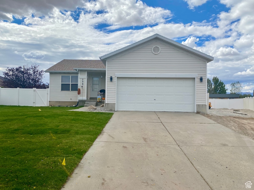 Single story home with concrete driveway, a gate, and a garage
