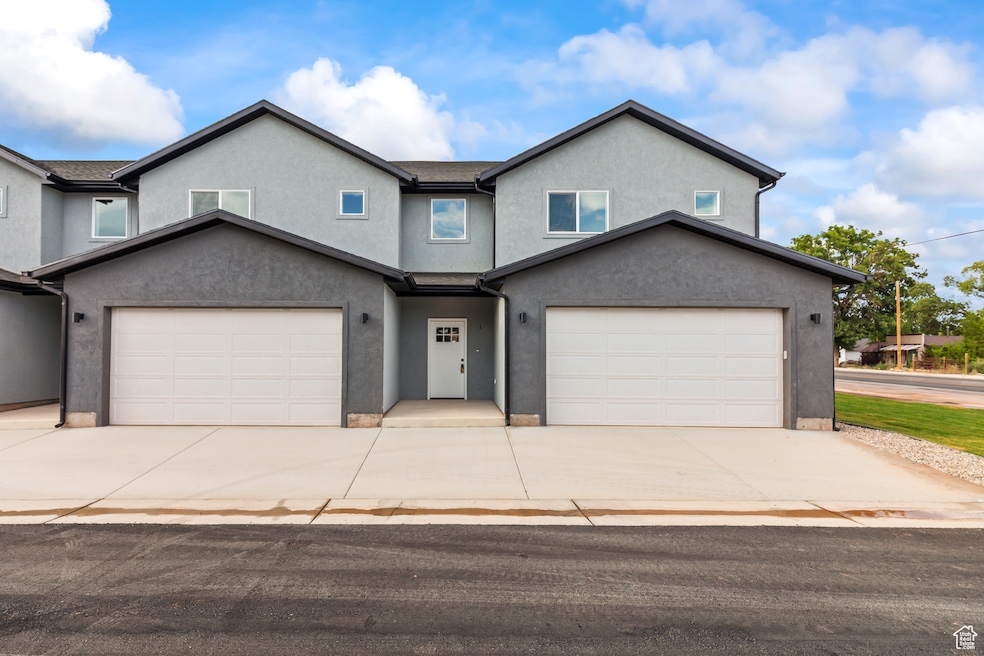 Traditional-style house featuring stucco siding, concrete driveway, and a garage