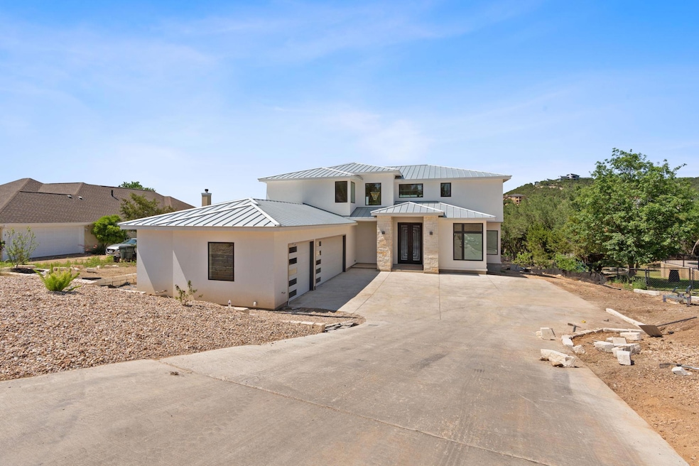 View of front facade with concrete driveway, a me